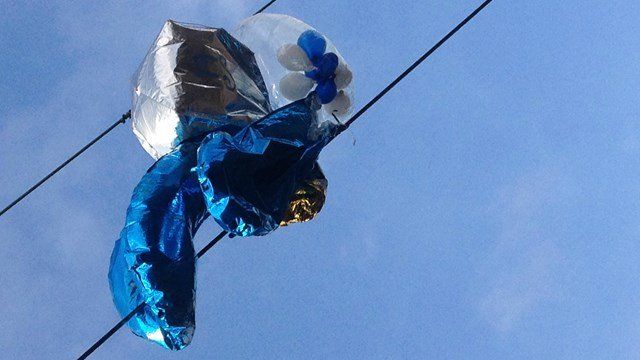 Helium balloons tangled in overhead railway power cables