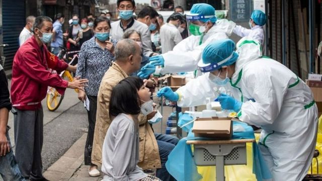 Medical workers take swab samples from residents to be tested for the COVID-19 coronavirus, in a street in Wuhan in China's central Hubei province on May 15, 2020.