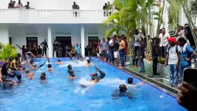 Protesters swim in the presidential palace swimming pool following storming it