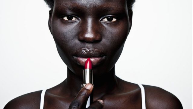mujer negra aplicando pintalabios