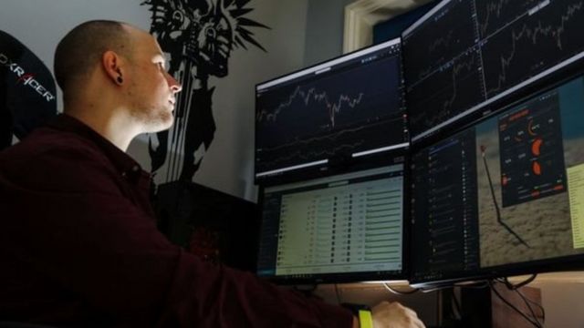 Un hombre delante de monitores de computadora