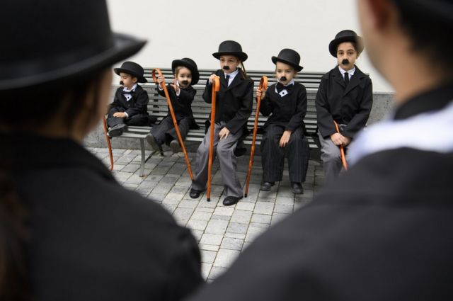 Children dressed as Charlie Chaplin pose for a group photo.