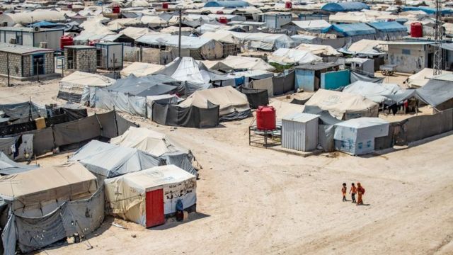 أطفال يسيرون بين الملاجئ في مخيم الهول الذي يديره الأكراد، والذي يحتجز أقارب مقاتلين يشتبه في أنهم من تنظيم الدولة الإسلامية (داعش)