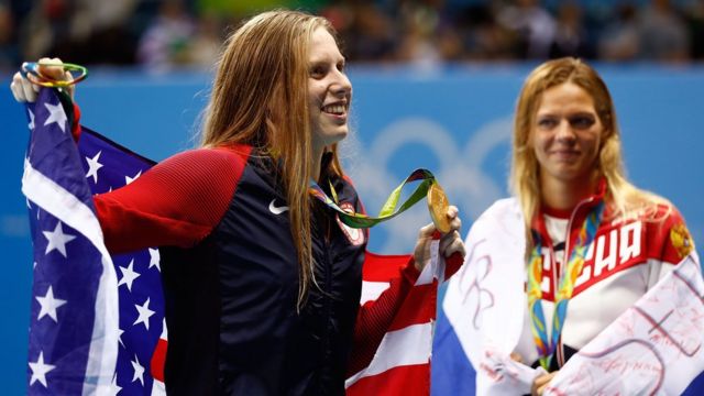 Lilly King enseña la medalla de oro conseguida en la categoría 100 metros pecho, mientras Efimova la mira con su medalla de plata en el cuello.