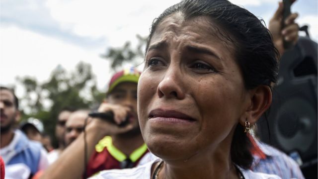 Una mujer venezolana llora durante una ceremonia de llegada de ayuda a la frontera entre Venezuela y Colombia