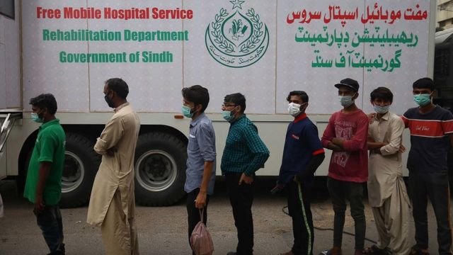 पाकिस्तान के एक वैक्सीन सेंटर पर अपनी बारी का इंतज़ार कर रहे लोग