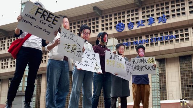 Pembela Huang bertopeng di depan Stasiun Taipei