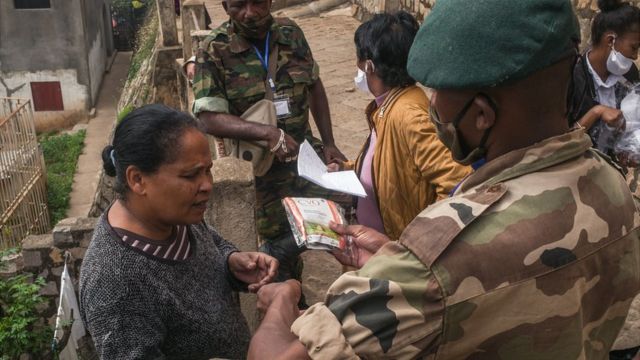 Des soldats de l'armée malgache distribuent des masques et des échantillons d'une tisane locale, présentée par le président Andry Rajoelina comme un puissant remède contre le coronavirus COVID-19, à la population du quartier Amboasarikely, au centre d'Antananarivo, le 22 avril 2020. (Photo par RIJASOLO / AFP) (Photo par RIJASOLO/AFP via Getty Images)