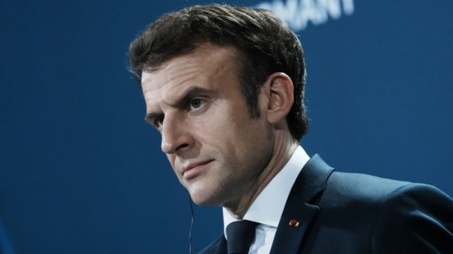 Macron de perfil, olhando atentamente para frente em evento