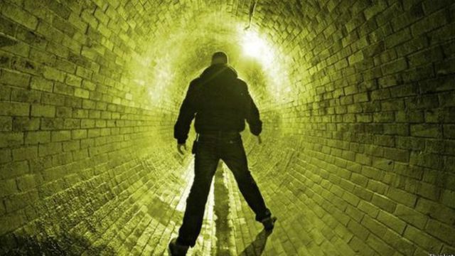 Un hombre dentro de un túnel de alcantarillas.