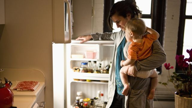 Woman in front of a fridge with her son