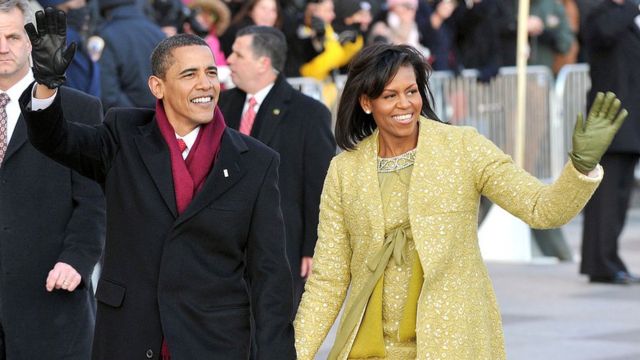 Barack e Michelle Obama acenando para o público