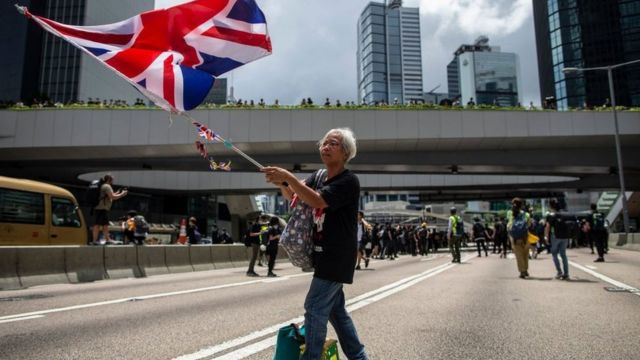 A woman holds a UK flag during a protest in Hong Kong in 2019