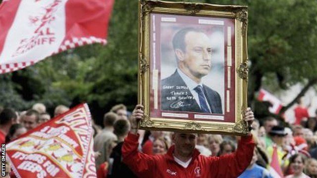A Liverpool fan holds up a picture of Benitez during the bus parade after the 2005 Champions League final