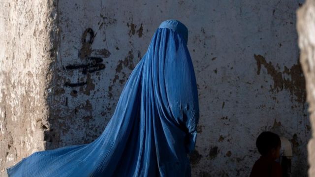امرأة أفغانية ترتدي البرقع تمشي مع طفل في كابل في 28 أبريل/نيسان 2022