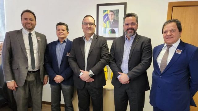 Cinco homens de terno alinhados