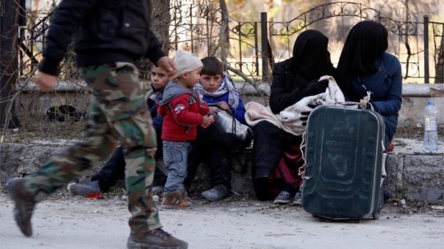 Orang-orang yang mengevakuasi diri dari distrik timur Aleppo menunggu di daerah yang dikuasai pemerintah di Aleppo, Suriah, 9 Desember 2016.