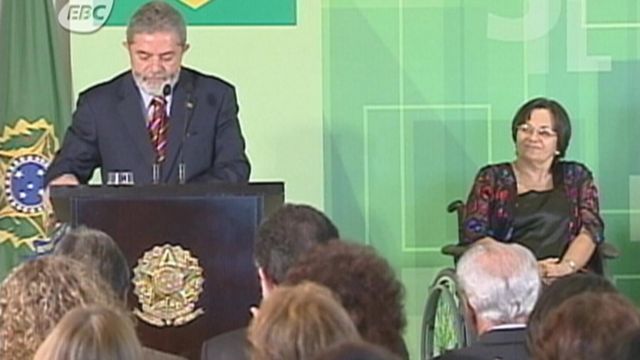 Maria da Penha onbserva enquanto então presidente Lula faz discurso após aprovação da lei pelo Congresso