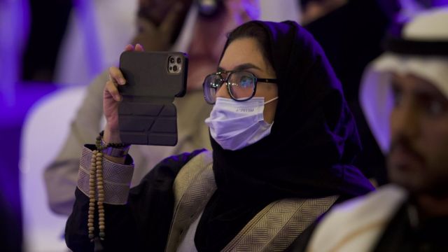Female student takes a photograph during the conference (Dec 2021)