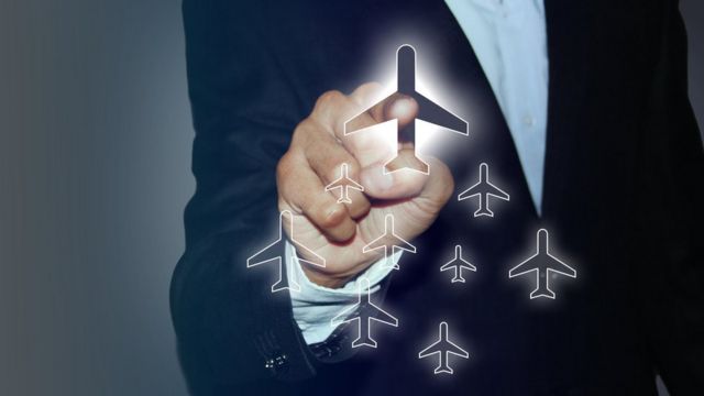 Una persona "haciendo clic" en un avión en una pantalla imaginaria