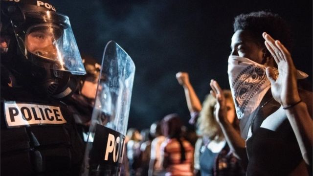 米ノースカロライナ州シャーロットで男性が警官に射殺されたことに抗議する人たちと、制止する警官隊