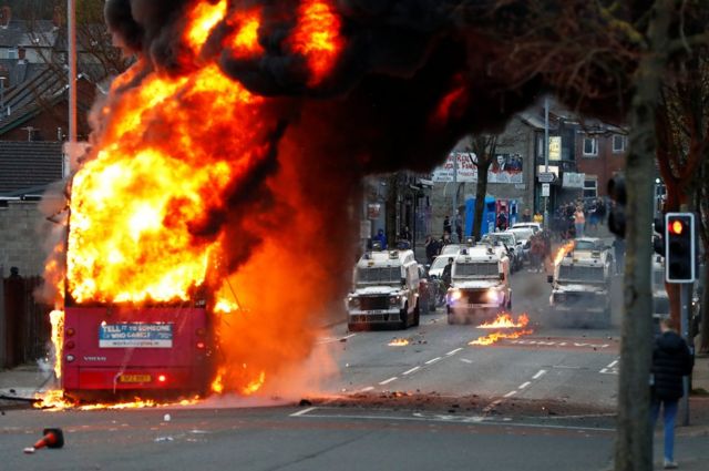 A bus burns on a street in west Belfast