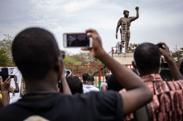 People take photos of the second bronze statue of Burkina Faso's former President Thomas Sankara on17 May 2020.