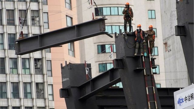 Trabalhadores da construção em andaime em canteiro de obras em Xangai