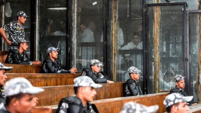 أعضاء من جماعة الإخوان المسلمين خلف القضبان أثناء محاكمتهم في العاصمة القاهرة في 28 يوليو/تموز 2018