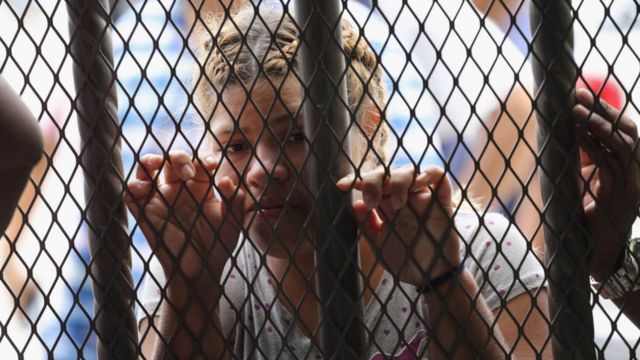 Una mujer detrás de las rejas en la frontera entre México y Guatemala.