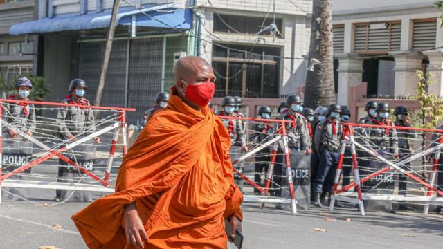 Một nhà sư trước hàng rào cảnh sát dựng lên để chặn người biểu tình ở Mandalay hôm 24/2/2021