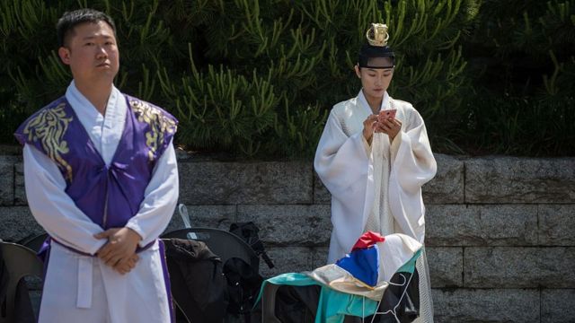 Un hombre y una mujer se preparan para una ceremonia tradicional en Corea del Sur.