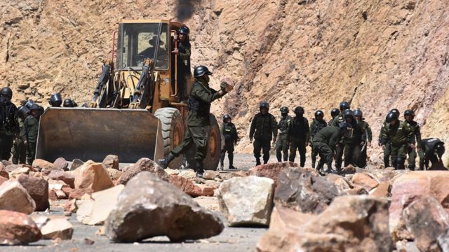 La policía retira piedras en una sección de carretera cerrada por los mineros