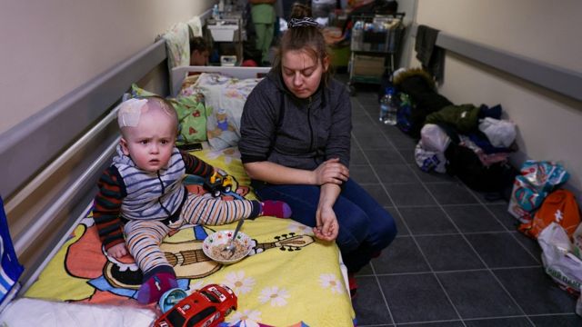 Una madre con su bebé que tiene un autito de juguete