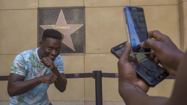 Eric Obeng, umunya Ghana, yiga muri kaminuza muri Amerika, ariko yifotoza mu kwibuka igihangange mw'iteramakofe yitavye Imana, Muhammad Ali, kukimeneytso c' inyenyeri ciwe mu bitonze kw'ibarabara rya Hollywood Walk of Fame kuwa gatandatu 04/06/2016...
