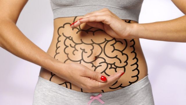 Mujer con el aparato digestivo dibujado en el cuerpo.