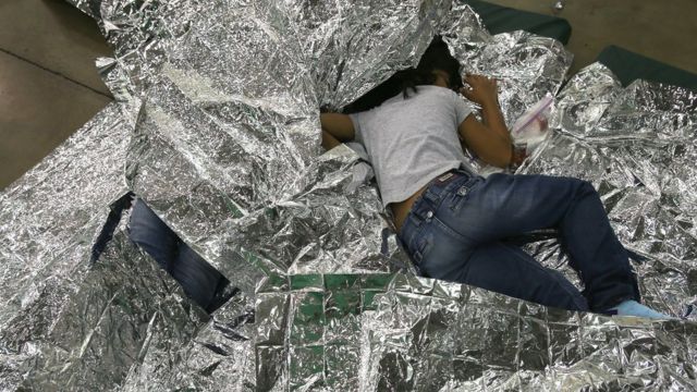 Una niña duerme encima de mantas isotérmicas en un lugar de detención de la Patrulla Fronteriza de EE.UU. en 2014.