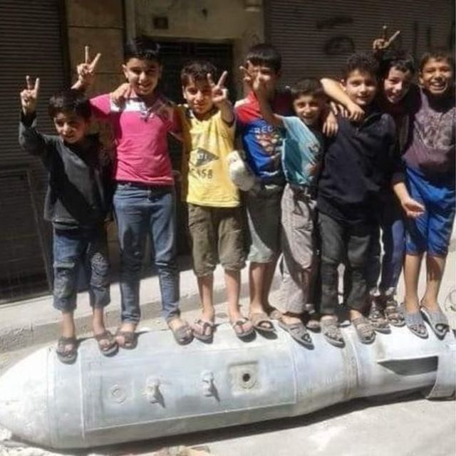 Abana bakinira hejuru y'igisasu mu gace ka al-Muyaser mu mujyi wa Aleppo.