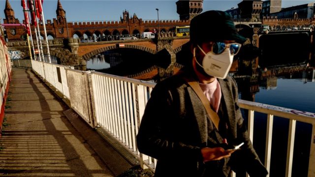 A woman in Berlin in a mask walking near the Oberbaum Bridge (2 March)