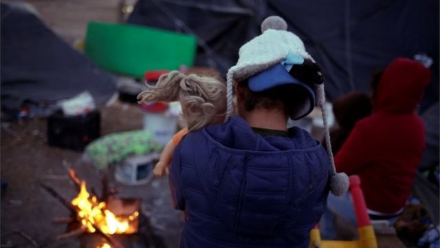 A Mexican girl hugs a doll in a make-shift camp in Ciudad Juarez