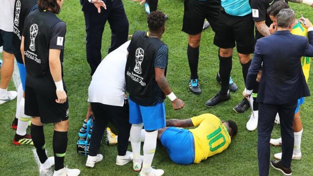 Neymar dikerumuni para pemain setelah mengeluh kesakitan. Pemain Brasil ini dikenal mudah jatuh dan dituduh sering sengaja diving.