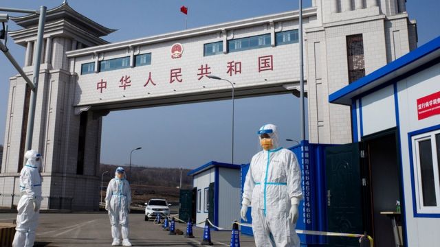 This photo taken on May 1, 2020 shows staff wearing hazmat suits as a precaution against the COVID-19 coronavirus waiting to check a truck at a customs checkpoint on the border with Russia at Suifenhe, in China's northeast Heilongjiang province.