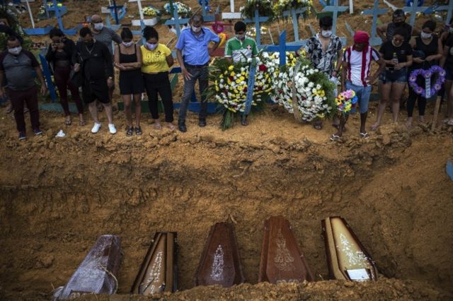 People attend a funeral at a mass grave at the Nossa Senhora Aparecida cemetery in Manaus, Brazil, 23 April 2020