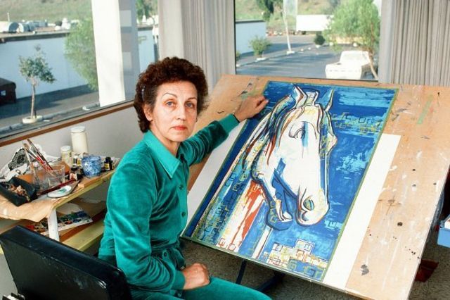 Françoise Gilot poses with a painting of hers