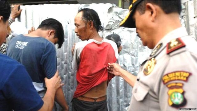 इंडोनेशियात गुन्हेगारांची तपासणी करताना स्थानिक पोलीस