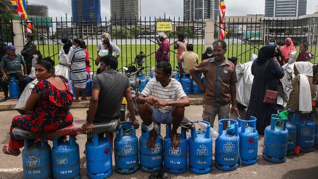 People wait outside a police station to buy cooking gas in Colombo, Sri Lanka, on May 14, 2022