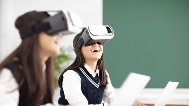 Estudante usa óculos de realidade virtual enquanto sorri