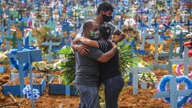 Gente abrazándose en un cementerio