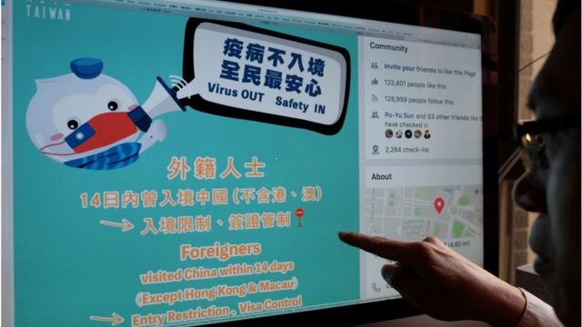 This photo illustration taken on February 14, 2020 shows a man pointing to a webpage from Taiwan's Ministry of Foreign Affairs Facebook account