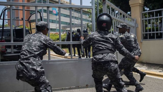 Policjanci biegną do budynku rządowego, w którym zginął minister Orlando Jorge Mera.